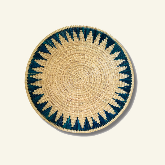 Teal Sikki grass handwoven round mat on a Dhoop Cream background